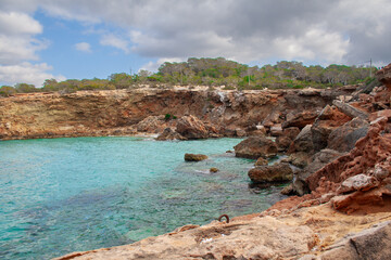 Rocky shore in a cloudy daywith blue water