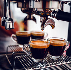 Professional espresso machine while preparing two espressos shot in a coffee shop. Close-up of espresso pouring from the coffee machine