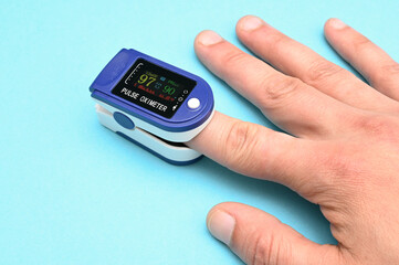 Pulse oximeter for measuring blood oxygenation pulse on a man's hand.