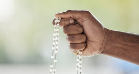 Rosary, person hand and prayer beads in a home with hop, christian praise and religion. Praying,...