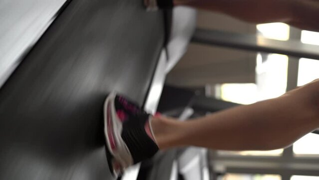 Close-up of young woman foot running on the treadmill while exercising in the fitness center