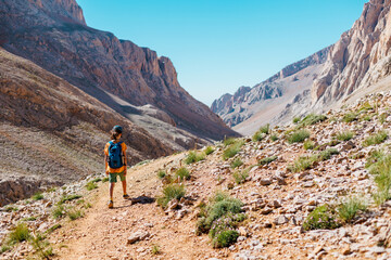 Naklejka premium child travels in the mountains with a backpack. mountain hike in high mountains. Turkey.