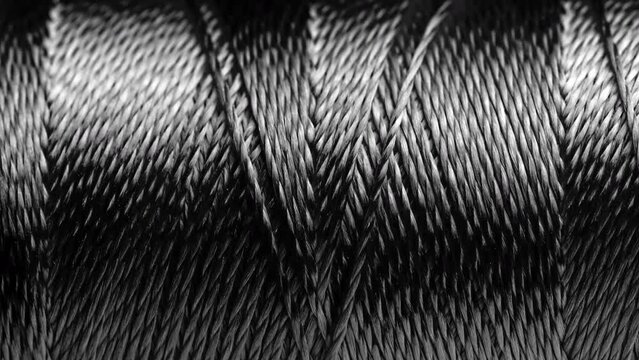 Texture of threads in a spool of black color.