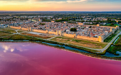 The pink salt lake and the medieval walled town of Aigues-Mortes, Camargue, France - 637889275