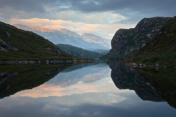 Beautiful mountain lake with mountain peaks reflecting in the water in the early morning hours. Loch na Thull. North West Sutherland, Scotland