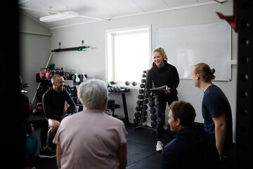 Smiling people talking together in gym