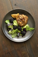 Roasted turkey thigh with green salad and blackberries, served with french mustard, vertical,
view from above