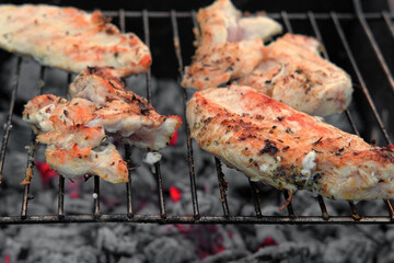 Chicken Fillet Bbq. Grilled Chicken Breast on the hot Grill with Smoke and Fire Flames. Juicy White Meat Steak. Delicious Poultry Roasted Cooked on a Charcoal Barbecue. Camping Food. Outdoors Cooking
