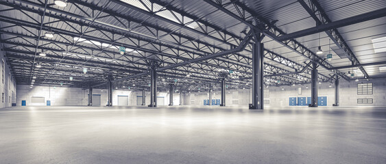 horizontal image of an empty warehouse with a metal structure.
