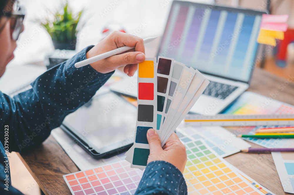 Fototapete Graphic designer architects who work with laptops and color comparison tables for design work..