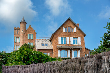 Fototapeta na wymiar Country house on red rocks at picturesque Ile de Brehat island in Brittany, in France