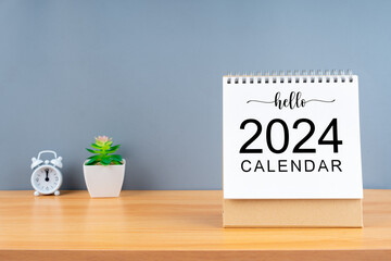 The Hello 2024 calendar on wooden table and gray background. New Year plans for 2024 concepts.