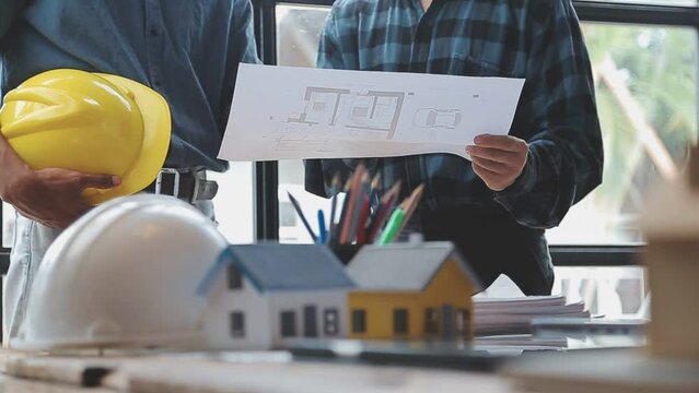 Image of team engineer checks construction blueprints on new project with engineering tools at desk in office.