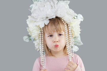 Adorable funny child baby girl in white flower hat closeup portrait