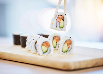 Sushi, food on wood board with fish and eating, salmon and rice with avocado, healthy and luxury. Japanese cuisine, catering with lunch or dinner meal, chopsticks and seafood, nutrition and gourmet