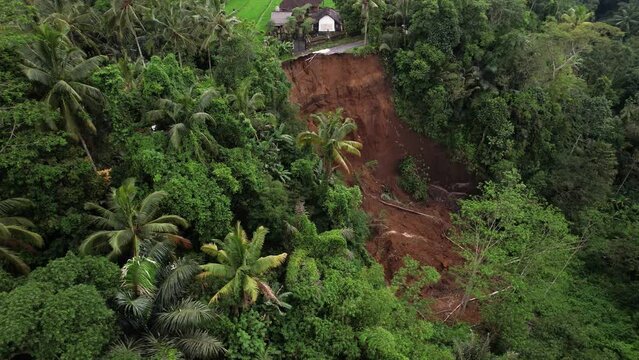The green gorge with its steep slopes is quite unstable and prone to landslides. Aerial view of landslip aftermath. One of reasons of mass wasting is apparently leaking irrigation canal