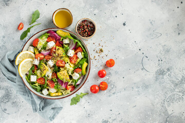 Delicious and healthy green salad of different leaves and vegetables with seeds and olive oil.