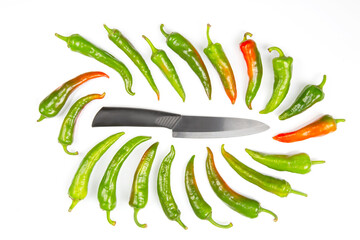 ceramic knife and green hot peppers on a white background. cooking vegetables for food