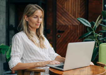 Attractive blonde businesswoman is working on a laptop.