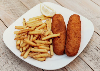 Plato de pechuga de pollo rebozada y frita, acompañada de patatas fritas