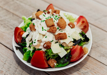 Plato gourmet de ensalada cesar con pollo, parmesano, y pan crujiente