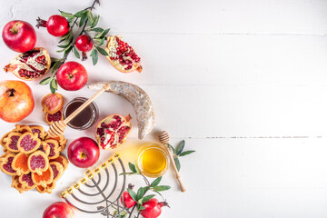 Rosh hashana jewish holiday background with red apples, honey, pomegranate, Shofar and goblet, jewish New Year holiday with traditional symbols. Happy Rosh hashana greeting card 