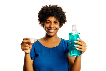 Young african girl holding mouthwash for fresh breath looking at the camera over white background.