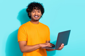 Portrait of young guy curls indian student distance education online use only laptop worldwide connection isolated on blue color background