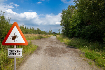 Warning sign for infected ticks in a forest. Risk of tick and Lyme disease.