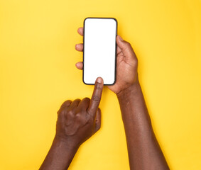 Man holding smart phone with blank screen isolated on yellow background