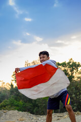 Naklejka premium Klaten, Central Java - August 17 2023 - boy waving the Indonesian flag