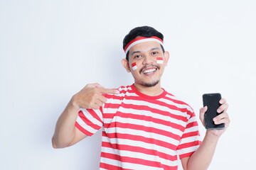 A portrait of a smiling Asian man wearing headband and showing his phone, isolated by white...