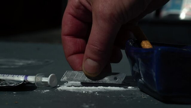 Drug addict preparing lines of cocaine 