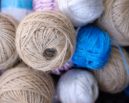 rolls of natural hemp wire for parcel twine, string, packing or diy.fencing strand,polypropylene orange, blue twine.spools in plastic bag,woman hand,market store sale concept