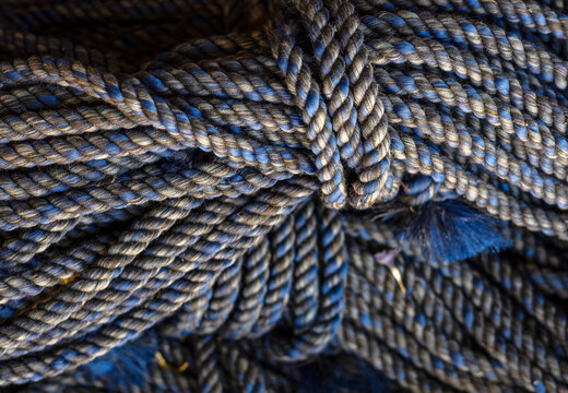 rolls of natural hemp wire for parcel twine, string, packing or diy.fencing strand,polypropylene orange, blue twine.spools in plastic bag,woman hand,market store sale concept