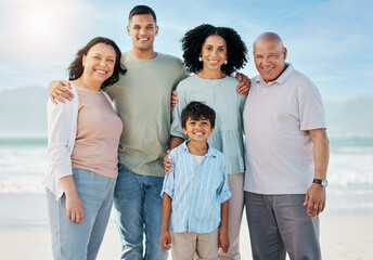 Obraz premium Portrait, grandparents and a family on the beach in summer together for holiday or vacation by the ocean. Love, nature or freedom with parents and children at the sea for bonding or weekend travel