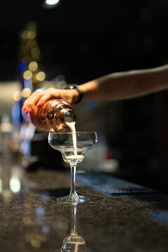 a girl putting a cocktail into a cup 