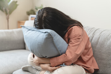 Stressed female feeling depressed and lonely on the sofa in the house.