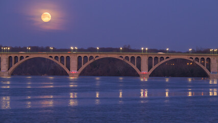 Almost Full Moon Disappearing into the Clouds Behind Key Bridge at Dawn