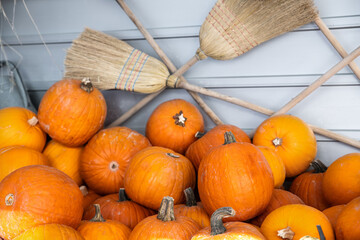 Pile of many ripe orange bright pumpkins against rustic straw hay broomstick at pumpkin farm yard....
