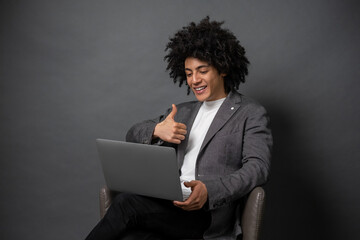 Curly-haired young manager working on laptop