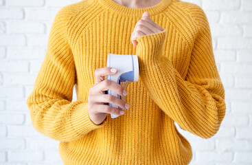 woman in yellow sweater using fabric pills removing tool