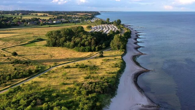 Drone shot, drone video, drone flight, aerial view, flight over sandy beach on the Baltic Sea coast, holiday homes, hotel, tower, tourist centre, pier, beach chairs, sailboats, motorboats, camping