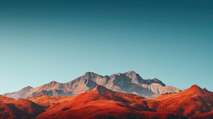 Naklejka premium A majestic mountain range adorned in hues of red, orange, and gold, set against a clear blue sky - Generative ai
