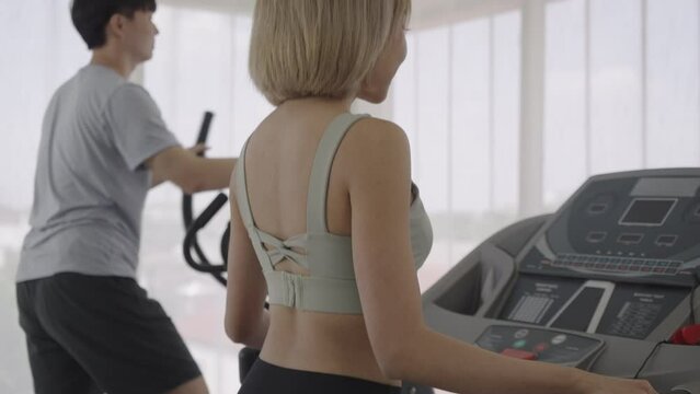 Man And Woman Running On A Treadmill At Home.