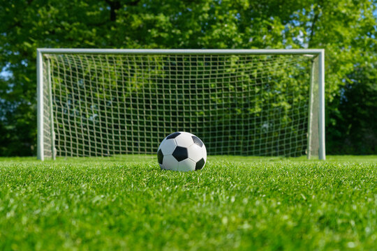 Fototapeta textured soccer game field with ball in front of the soccer goal. - center, midfield