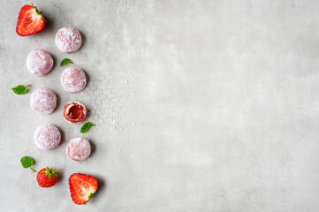 Rows of mochi with strawberries on a gray background.