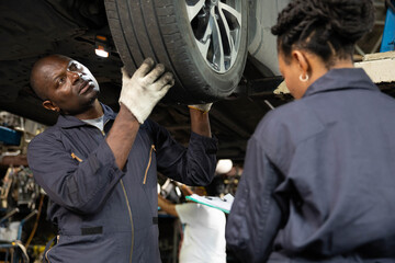 Fototapeta na wymiar African mechanic workers fixing and checking a car or tire in automobile repair shop