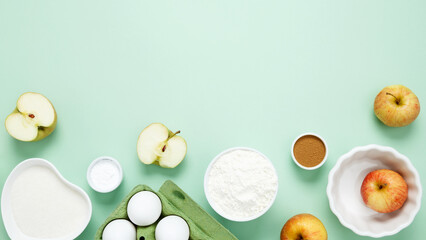 Ingredients for making classic cake pie with apples on green background. Concept homemade food,...
