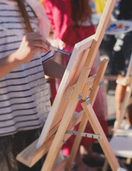 Process of drawing, group class of talented students with painting easels and canvases during...